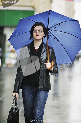 Image of woman on street with umbrella