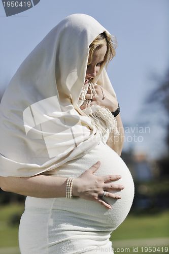 Image of happy young pregnant woman outdoor