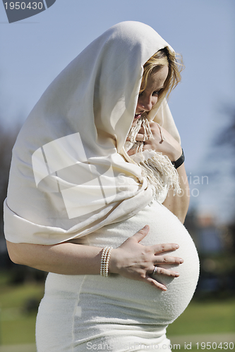 Image of happy young pregnant woman outdoor