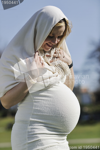Image of happy young pregnant woman outdoor
