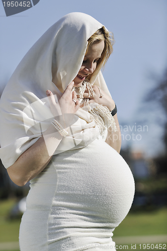 Image of happy young pregnant woman outdoor
