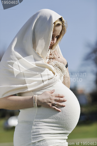 Image of happy young pregnant woman outdoor