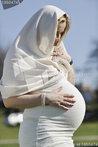 Image of happy young pregnant woman outdoor