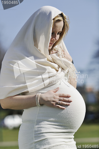 Image of happy young pregnant woman outdoor