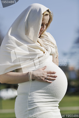 Image of happy young pregnant woman outdoor