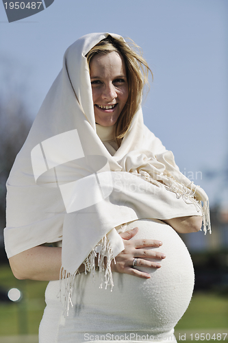 Image of happy young pregnant woman outdoor