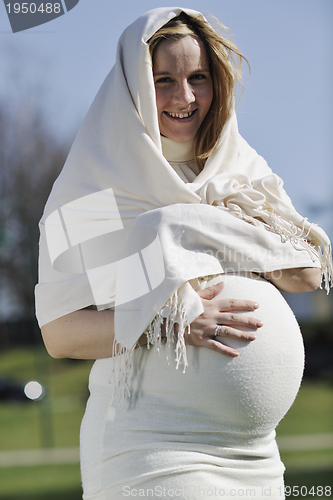 Image of happy young pregnant woman outdoor