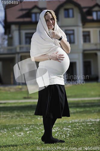 Image of happy young pregnant woman outdoor