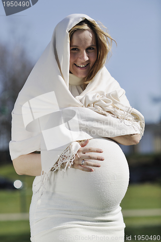 Image of happy young pregnant woman outdoor