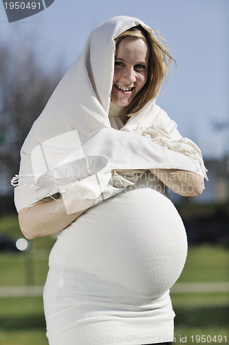 Image of happy young pregnant woman outdoor