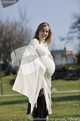 Image of happy young pregnant woman outdoor
