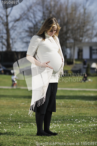 Image of happy young pregnant woman outdoor