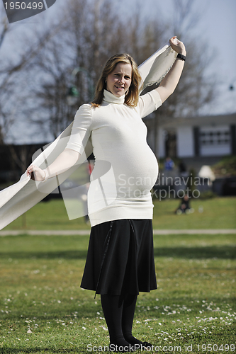 Image of happy young pregnant woman outdoor