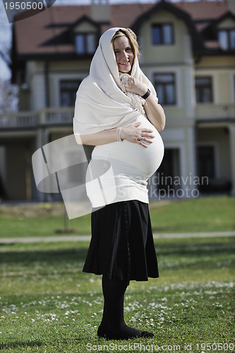 Image of happy young pregnant woman outdoor