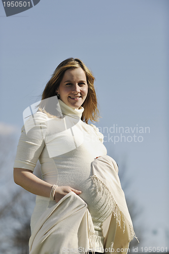 Image of happy young pregnant woman outdoor