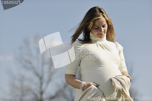 Image of happy young pregnant woman outdoor