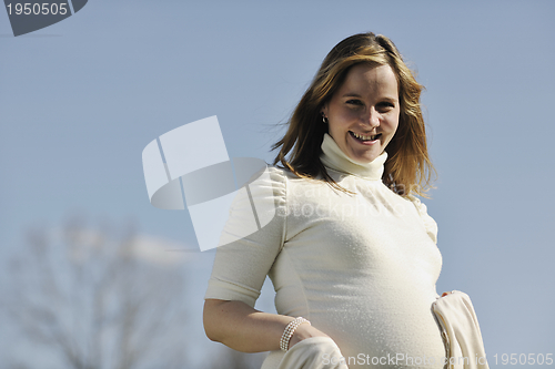 Image of happy young pregnant woman outdoor