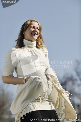 Image of happy young pregnant woman outdoor