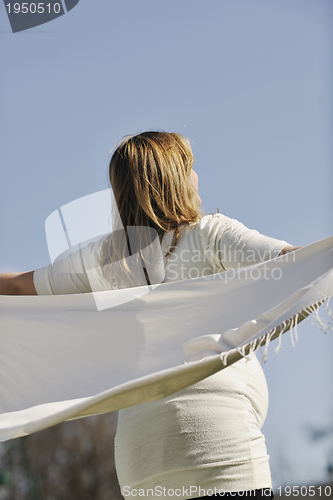 Image of happy young pregnant woman outdoor