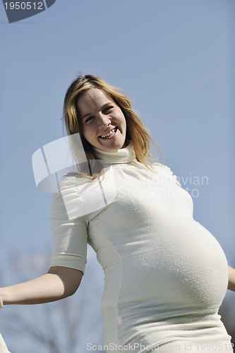 Image of happy young pregnant woman outdoor