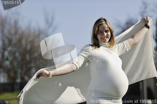 Image of happy young pregnant woman outdoor