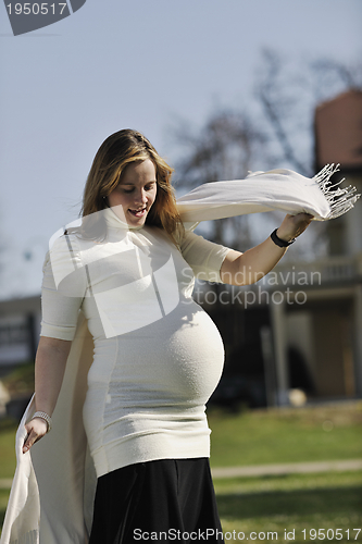Image of happy young pregnant woman outdoor