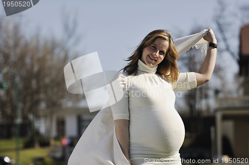 Image of happy young pregnant woman outdoor