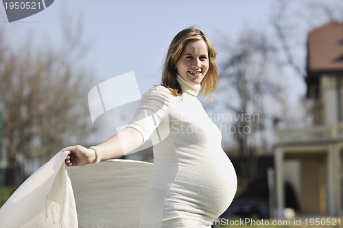 Image of happy young pregnant woman outdoor