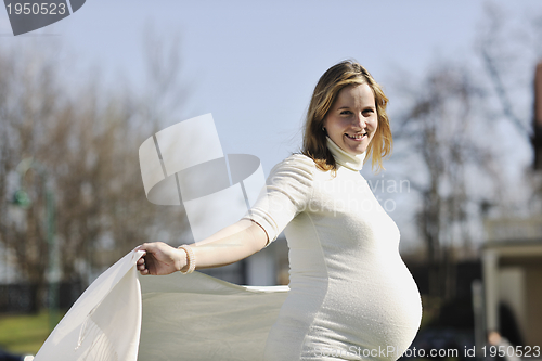Image of happy young pregnant woman outdoor