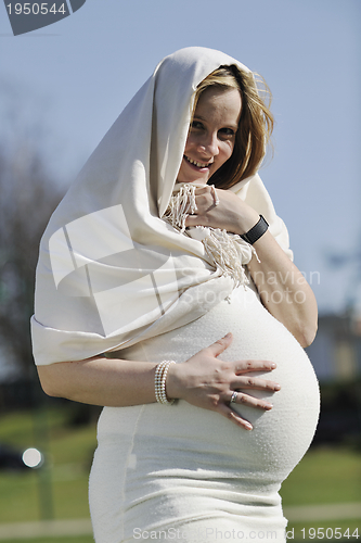 Image of happy young pregnant woman outdoor