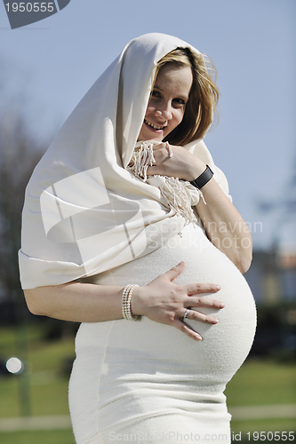 Image of happy young pregnant woman outdoor