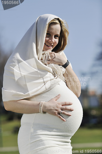 Image of happy young pregnant woman outdoor