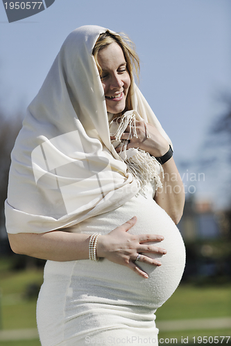 Image of happy young pregnant woman outdoor