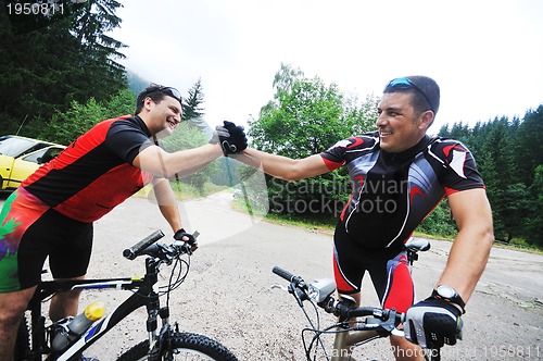 Image of friendship and travel on mountain bike