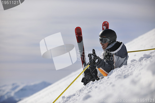 Image of young skier relaxing at beautiful sunny winter day