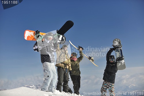 Image of snowboarders group relaxing and enjoy sun