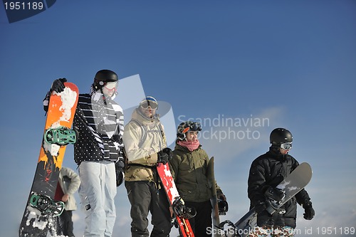 Image of snowboarders group relaxing and enjoy sun