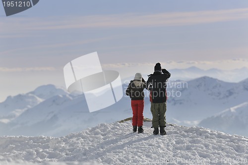 Image of snowboarder's couple on mountain's top