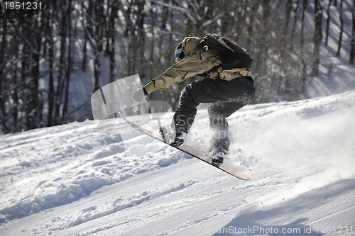 Image of freestyle snowboarder jump and ride