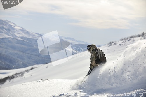 Image of freestyle snowboarder jump and ride