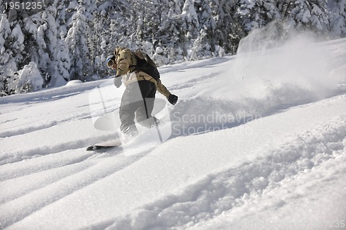 Image of freestyle snowboarder jump and ride