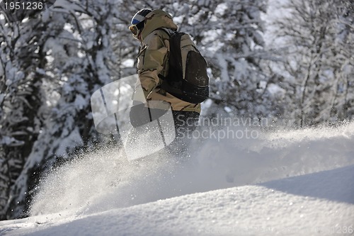 Image of freestyle snowboarder jump and ride