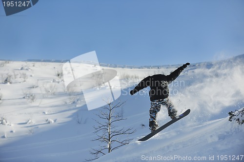 Image of freestyle snowboarder jump and ride