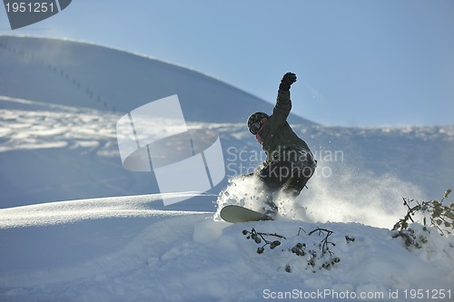 Image of freestyle snowboarder jump and ride