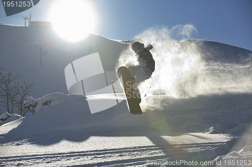 Image of freestyle snowboarder jump and ride