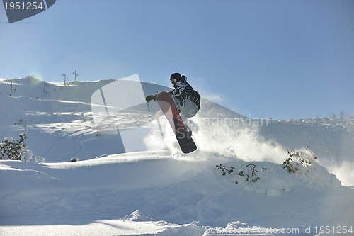 Image of freestyle snowboarder jump and ride