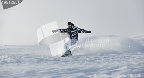 Image of freestyle snowboarder jump and ride