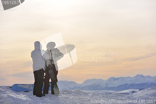 Image of snowboarder's couple on mountain's top