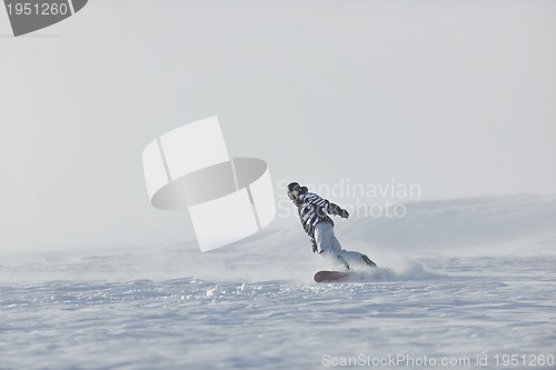 Image of freestyle snowboarder jump and ride