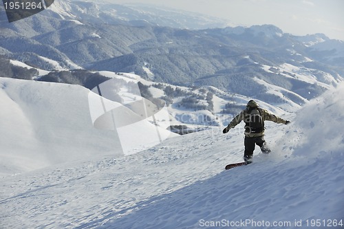 Image of freestyle snowboarder jump and ride